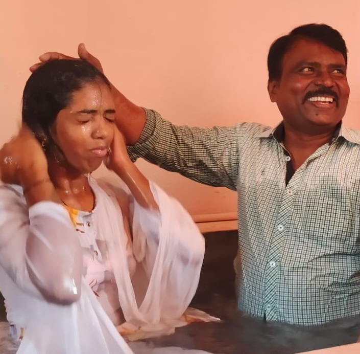Pastor Moses baptizing a young woman